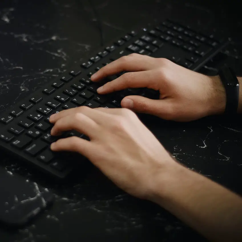 Hands typing at a keyboard